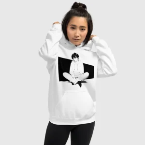 A woman wearing a white hoodie with a manga design of an anime boy sitting