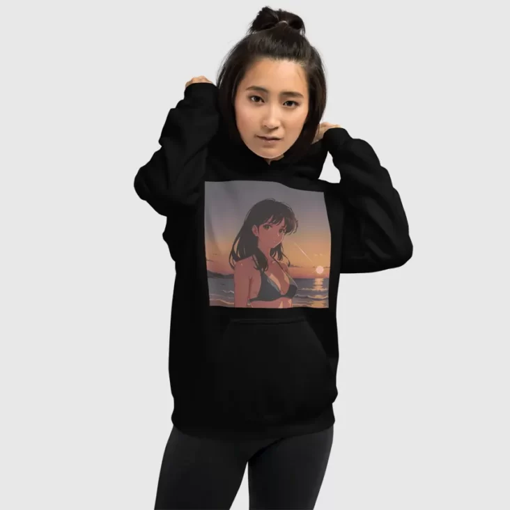 A woman putting on the hood of a black hoodie with a design of a 90s anime girl in the beach in a retro vintage style